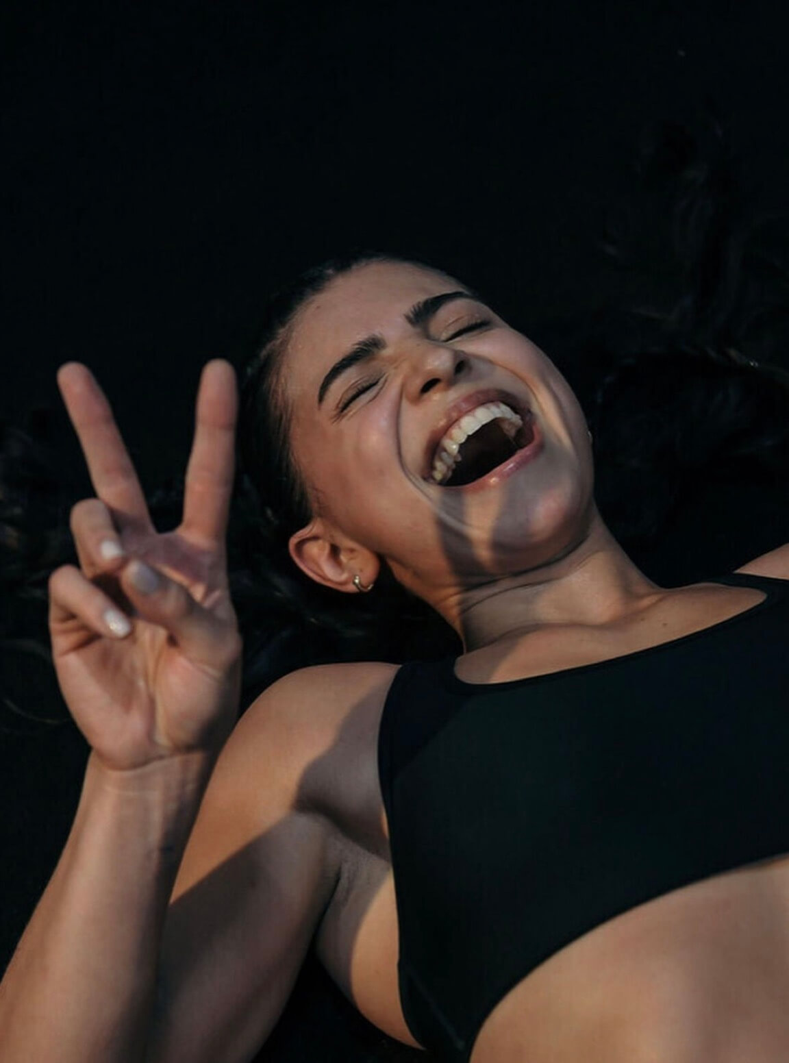 Alumna riendo y haciendo la señal de paz después de entrenar